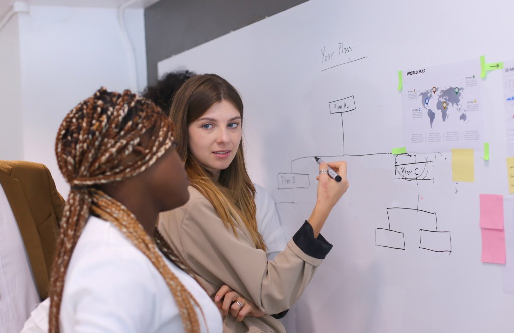 Business people discussing the charts and graphs showing the results of their successful teamwork, multi ethnic business